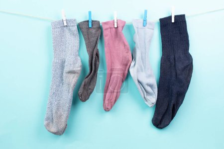 Photo for Lost socks hanging on a clothes line with clothespin, missing sock match after washing, memorial day - Royalty Free Image