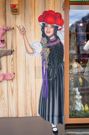 Téléchargez les photos : Peinture d'une femme avec des vêtements traditionnels, magasin à la Forêt Noire, Lac Titisee Neustadt en Allemagne, Bollenhut avec pompons en laine, 30.03.2024 - en image libre de droit