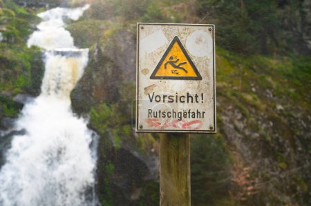 Téléchargez les photos : Panneau d'avertissement glissant, cascade de Triberg dans la Forêt Noire, chute la plus élevée en Allemagne, la rivière Gutach plonge sur sept étapes majeures dans la vallée - en image libre de droit