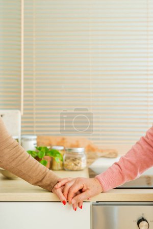 Photo for Close up picture of a senior couple holding hands in the kitchen, showcasing a tender moment of connection and affection. - Royalty Free Image