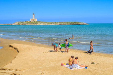 Photo for Vieste, Italy. View of the beach of Lungomare Cristoforo Colombo with some people at the beach. In the distance the Vieste lighthouse. September, 05, 2022. - Royalty Free Image