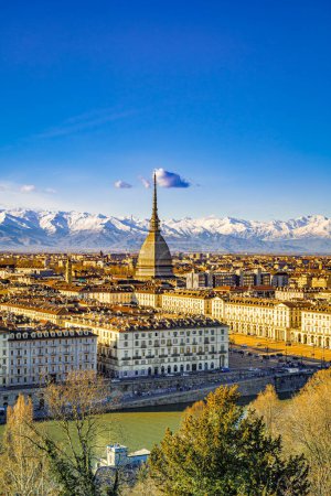 Turin, Italy. View of the city from above with the Dome of the Mole Antonelliana and buildings in the centre, from the Cappuccini hill. Snow-capped mountains of the Alps in the background. 2024-03-12.