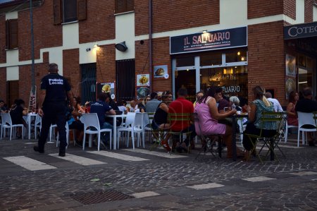 Foto de Personas sentadas y comiendo en un restaurante durante una feria en un pueblo - Imagen libre de derechos