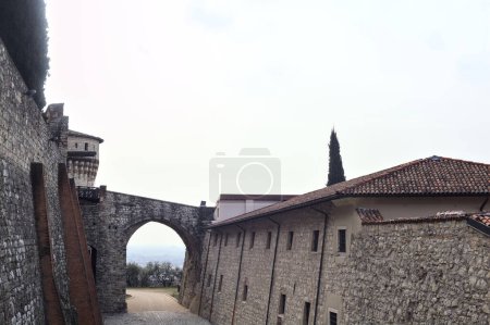 Photo for Stone bridge and the gate of a castle seen from the distance on a cloudy day - Royalty Free Image