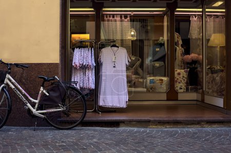 Foto de Calle estrecha a la sombra con tiendas y gente que pasa en un día soleado en una ciudad italiana - Imagen libre de derechos