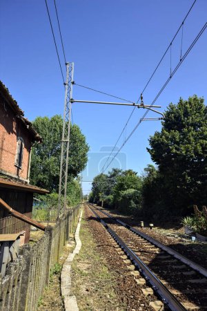 Foto de Ferrocarril que pasa por una arboleda en un día soleado en el campo italiano - Imagen libre de derechos