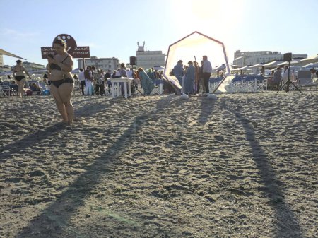 Téléchargez les photos : Mariage au bord de l'estran au coucher du soleil avec des passants - en image libre de droit