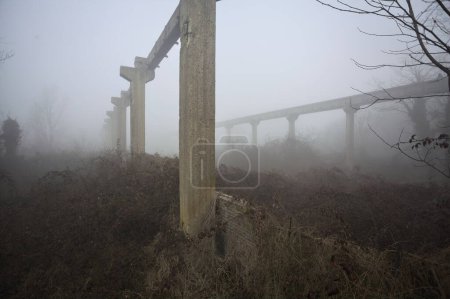 Balken einer verlassenen Fabrik im Nebel