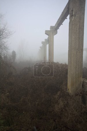 Beams of an abandoned factory in the fog