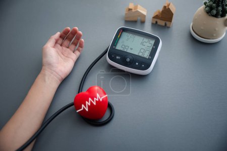 Photo for Self blood pressure and heart rate measurement with blood pressure monitor machine, healthcare and medical concept - Royalty Free Image