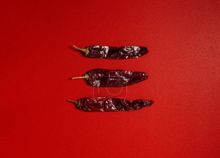 Téléchargez les photos : Séché Chilis fond rouge, piment guajillo mexicain épice plat laïc - en image libre de droit