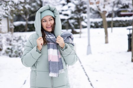 Téléchargez les photos : Jeune femme en vêtements chauds par une journée froide enneigée - en image libre de droit