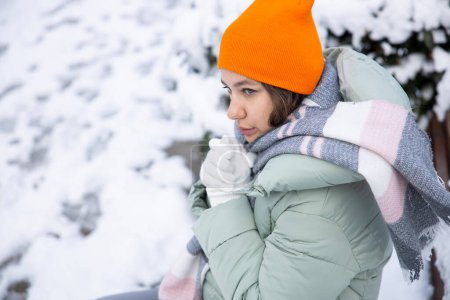 Téléchargez les photos : Jeune femme en vêtements chauds par une journée froide enneigée - en image libre de droit