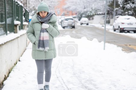Téléchargez les photos : Jeune femme marchant dans la ville par une journée d'hiver enneigée - en image libre de droit