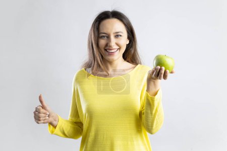 Téléchargez les photos : Smiling happy young woman holding an apple. Healthy nutrition, diet food concept. - en image libre de droit