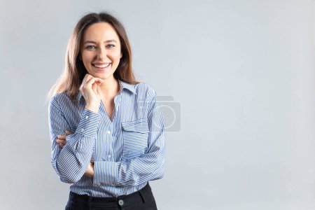 Téléchargez les photos : Heureuse femme d'affaires souriante touchant son menton avec un grand espace de copie - en image libre de droit