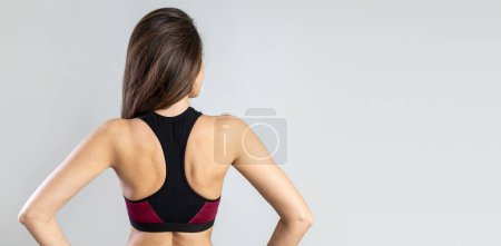 Foto de Retrato de vista trasera de una mujer fitness sobre fondo gris - Imagen libre de derechos