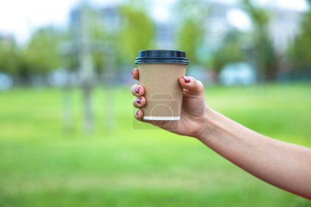 Téléchargez les photos : Gros plan de la jeune femme tenant une tasse de café à emporter cu - en image libre de droit