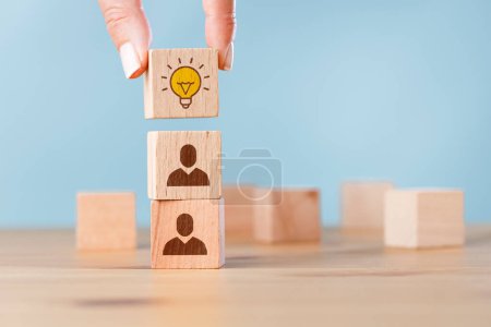Photo for Woman hand picked wooden cube block with head human symbol and light bulb icon. Creative idea and innovation. - Royalty Free Image