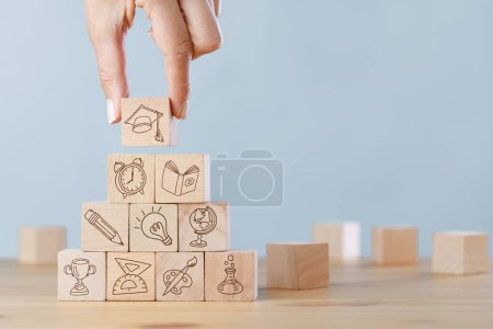 Photo for Female hand arranging wood block stacking with elements education icons - Royalty Free Image