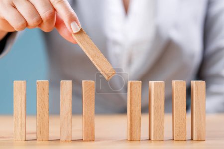 Photo for Business woman is placing wooden dominoes. Business, risk management, solution, strategy and investing concepts - Royalty Free Image