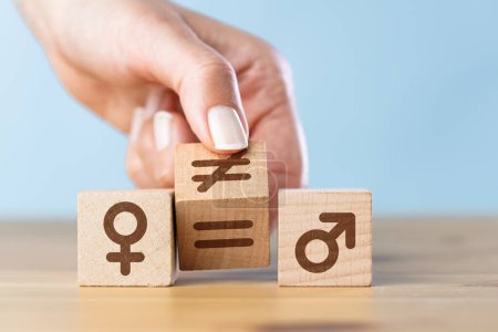 Foto de Conceptos de igualdad de género. Mujer mano voltear cubo de madera con símbolo desigual cambio a signo igual - Imagen libre de derechos
