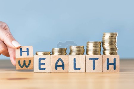 Woman hand flip wooden cube with word of wealth to health under the coins stack