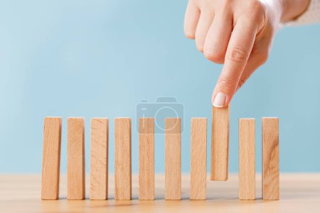 Photo for Female hand putting wooden block in a row on the table for business concept - Royalty Free Image