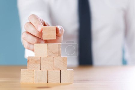 Téléchargez les photos : Gros plan d'un homme d'affaires construisant des blocs de cube. Concept d'entreprise processus de réussite de croissance - en image libre de droit