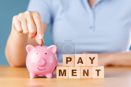 Photo for Woman hand putting money to piggy ban - Royalty Free Image