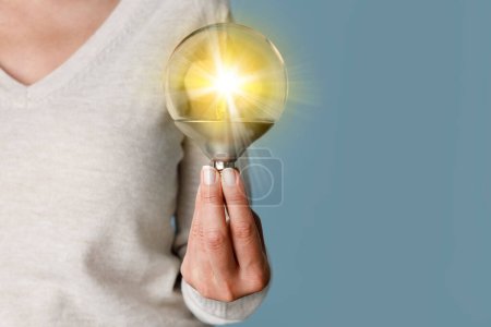 Foto de Mujer sosteniendo bombilla iluminada, idea y concepto de innovación. Creatividad con bombilla que brilla con brillo - Imagen libre de derechos