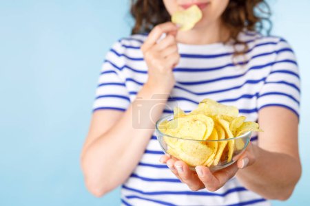 Photo for Woman on diet can't resist craving to eat potato chips. Food addiction, diet breakdown, compulsive overeating concept - Royalty Free Image