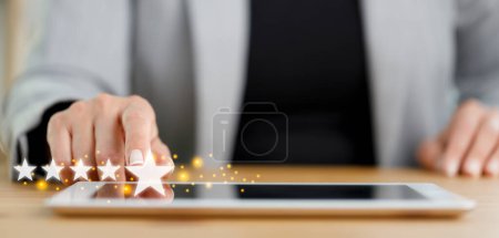 Téléchargez les photos : Businesswoman main appuyant sur l'écran de tablette PC avec cinq étoiles évaluation commentaires des clients - en image libre de droit