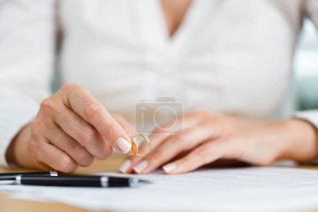 Photo for Hands of female who is about to taking off her wedding ring. Divorce concept - Royalty Free Image