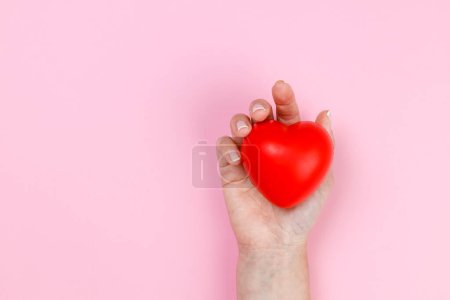 Téléchargez les photos : Main de femme tenant coeur rouge, soins de santé, don et concept d'assurance familiale, journée mondiale du cœur, journée mondiale de la santé, concepts de la Saint-Valentin - en image libre de droit