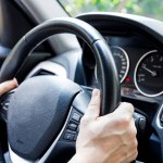 Male driver hand holding on steering wheel. Urban driving lifestyle