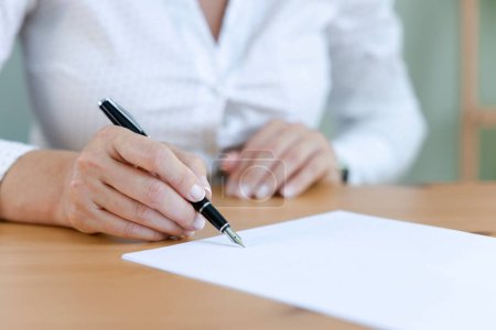 Téléchargez les photos : Femme d'affaires signant un document officiel - en image libre de droit