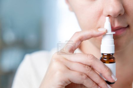 Photo for Close-up shot of sick young woman using nasal spray - Royalty Free Image