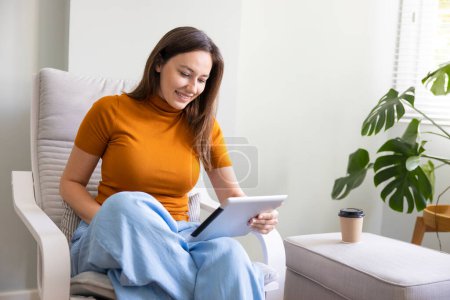 Photo for Young woman using digital tablet computer at home. Home work or online shopping, distance learning, education online, e-commerce, freelance concep - Royalty Free Image