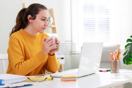 Photo for Businesswoman working on laptop computer in home office. Business, freelance work, creative occupation, online learning, lockdown, distance studying concept - Royalty Free Image