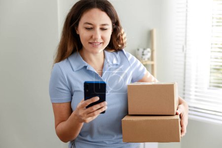 Photo for Satisfied young woman giving delivery confirmation to her online order from mobile app - Royalty Free Image