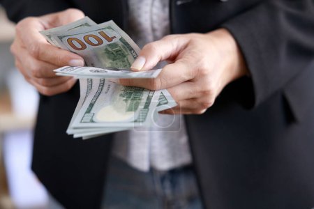 Téléchargez les photos : Mains de femme d'affaires comptant des billets de cent dollars - en image libre de droit