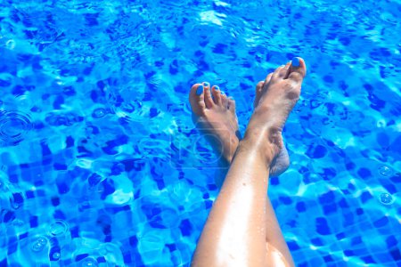 Photo for Feet of a woman on the swimming pool - Royalty Free Image