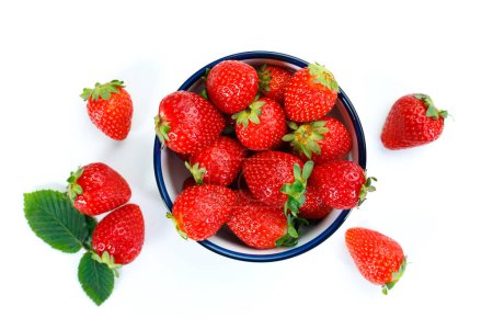 Téléchargez les photos : Délicieuses fraises fraîches dans un bol sur un fond blanc isolé - en image libre de droit