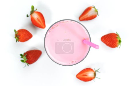 Foto de Un vaso de licuado de fresa fresca y fresas frescas maduras sobre un fondo blanco. Bebida de verano, batido. Vista superior - Imagen libre de derechos