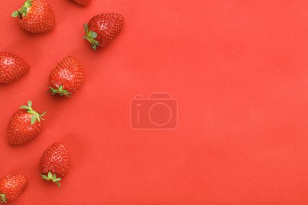 Foto de Vista superior de fresas frescas sobre fondo rojo - Imagen libre de derechos