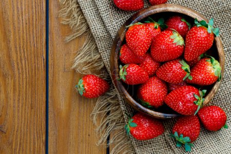 Photo for Fresh ripe strawberries in a the wooden bowl - Royalty Free Image