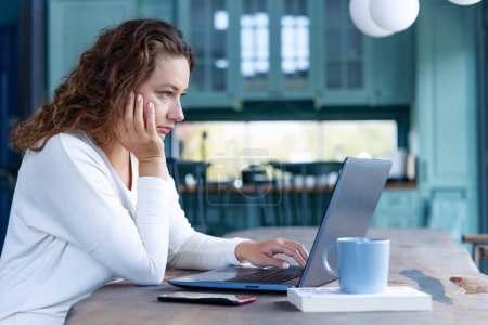 Téléchargez les photos : Inquiète freelance jeune femme regardant ordinateur portable - en image libre de droit