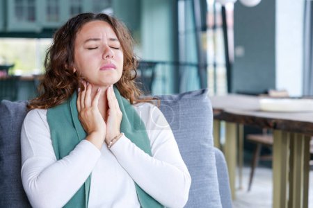 Téléchargez les photos : Jeune femme touchant le cou douloureux, mal de gorge pour la grippe, le rhume et l'infection - en image libre de droit