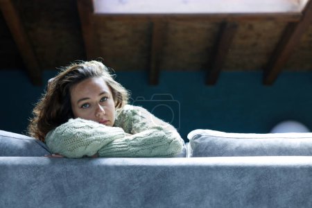 Photo for Young woman lying at home in living room sitting on sofa. She feeling sad and worried suffering depression in mental health. Problems and broken heart concept - Royalty Free Image